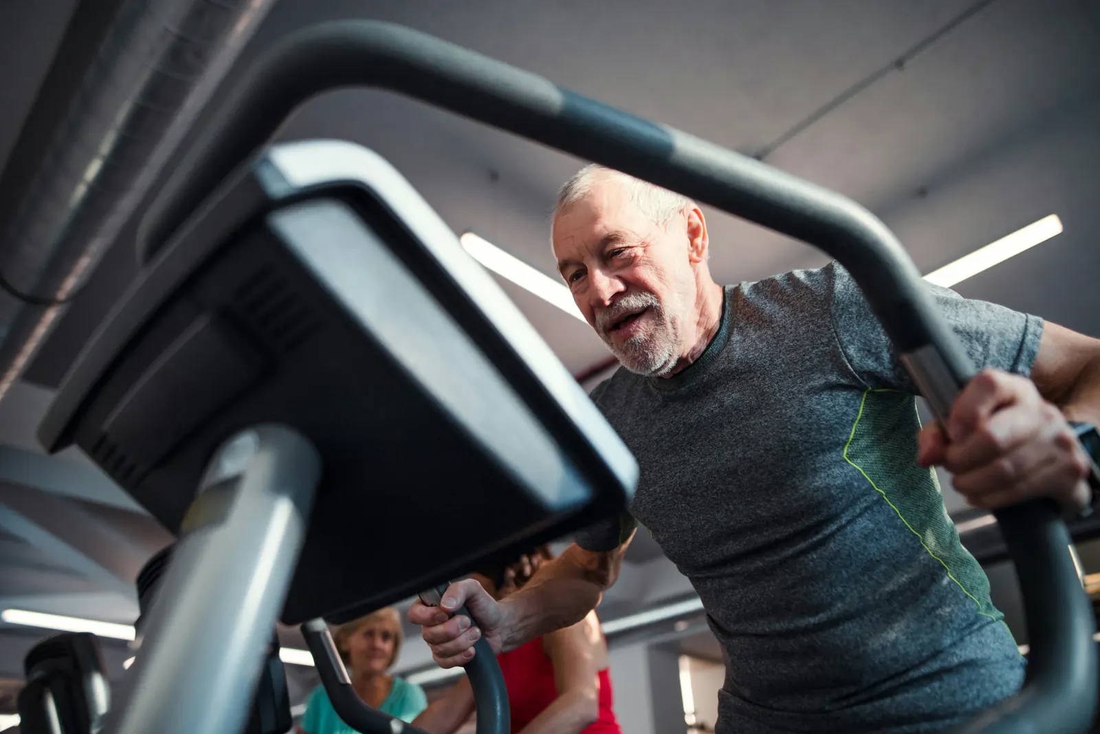 Active older adult exercising on a cardio machine at the gym