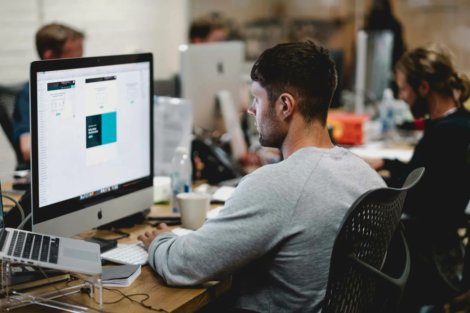 Professional working at a desktop computer in a busy office