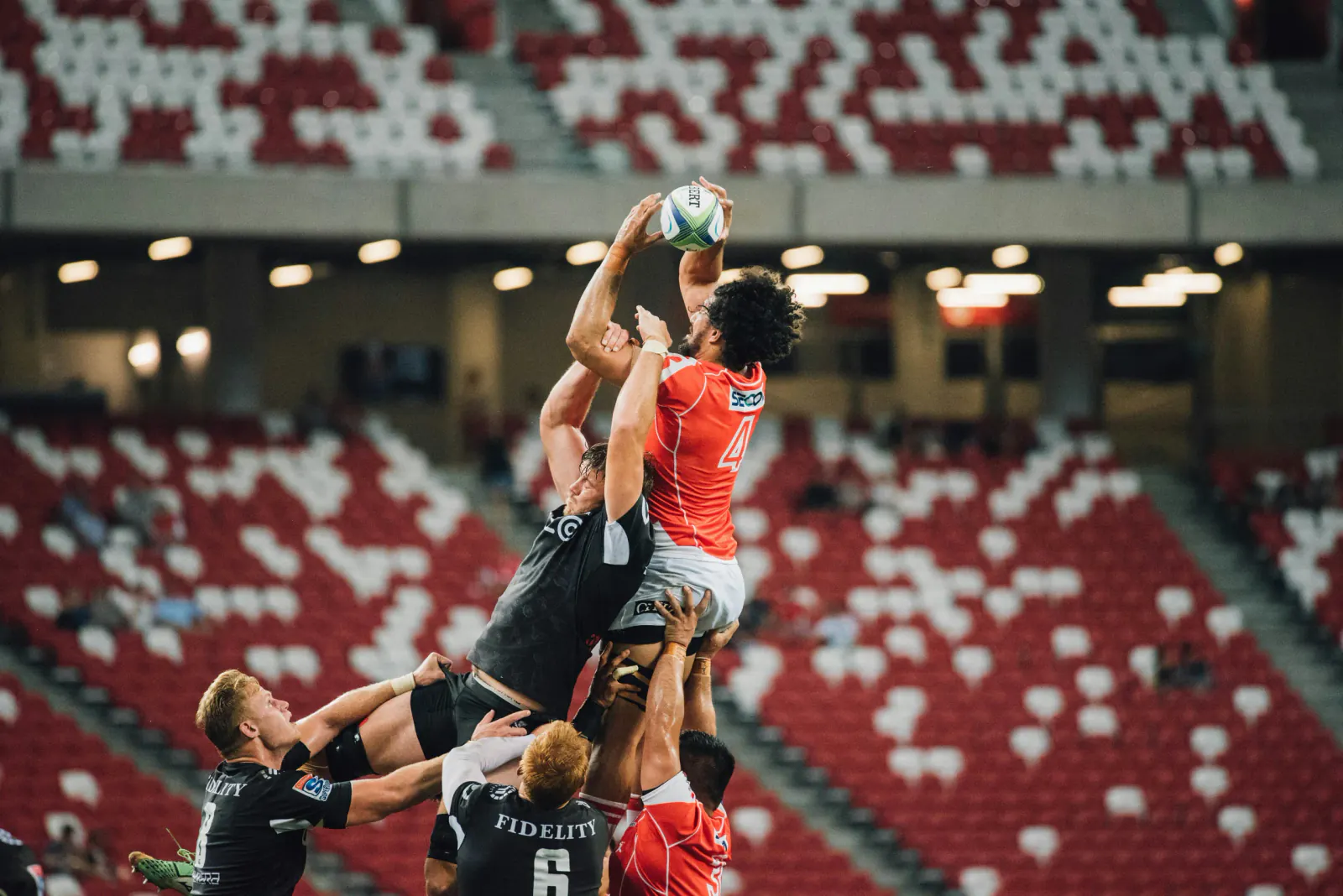Rugby players contesting a lineout in a stadium